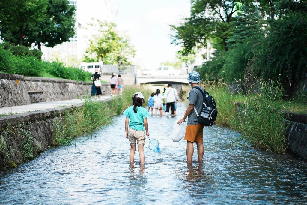 まちの川で遊ぶ子どもたち